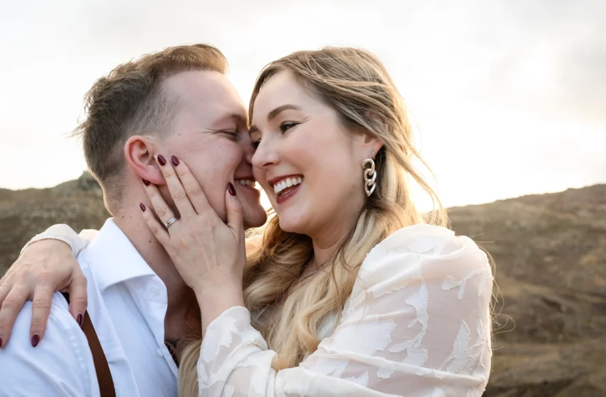 Close-up joyful couple laughing and sharing an intimate moment, with a soft natural backdrop